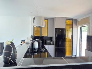 a kitchen with black and white appliances and yellow cabinets at Palmview in Bulawayo +4 photos