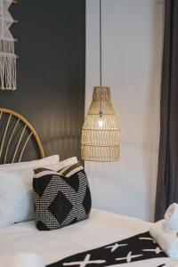 a bed with a black and white pillow and a lamp at The Orpen Kruger, Cork Tree Collection in Welverdiend