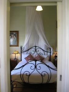 タウンズビルにあるClassique Bed & Breakfastのベッドルーム1室(天蓋付きの大型ベッド1台付)