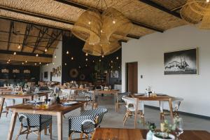 a dining room with wooden tables and chairs at The Orpen Kruger, Cork Tree Collection in Welverdiend