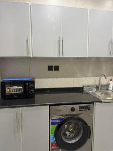 a kitchen with a washing machine and a sink at شقق سدايم in Jeddah