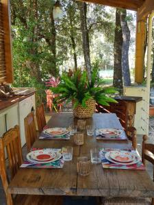 a wooden table with plates and glasses on a porch at a casetta di a Faragina in Zonza +19 photos