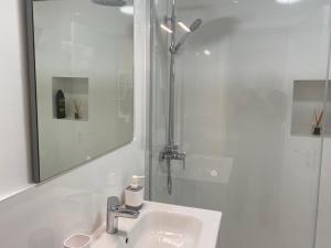 a white bathroom with a sink and a shower at Beach Flor Bungaló 42 La Gema del Sur in Maspalomas