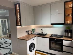 a kitchen with white cabinets and a washer and dryer at Sunny Escape in Gonio in Gonio