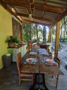 a wooden table with plates and glasses on a patio at a casetta di a Faragina in Zonza