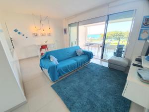 a living room with a blue couch and a blue rug at Appartamento Delfino Bianco in Golfo Aranci