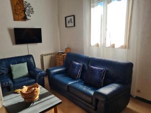 a living room with two blue leather couches and a table at a casetta di a Faragina in Zonza
