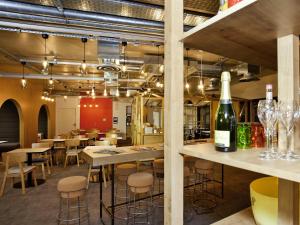 a restaurant with tables and chairs and a bottle of wine at ibis Styles Chalons en Champagne Centre in Chalons en Champagne