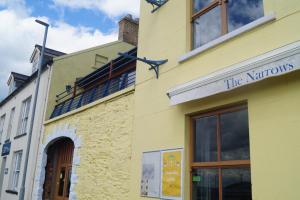 a yellow building with a sign that reads the neutrons at The Narrows Guesthouse in Portaferry