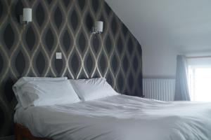 a bedroom with a large bed with a padded headboard at The Narrows Guesthouse in Portaferry