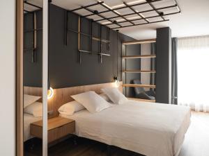 a bedroom with a white bed and a black wall at Hotel Can Batiste in Sant Carles de la Ràpita