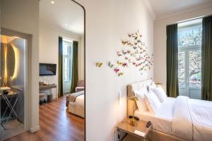 a bedroom with a bed and a room with a mirror at Nine Athens Hotel in Athens