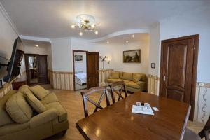 a living room with a table and a couch at Gusarskiy Hotel and Apartment in Kyiv