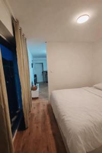 a bedroom with a large white bed and a hallway at Basel Access Apart - Habsheim in Habsheim