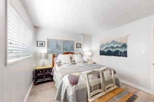 a white bedroom with a bed and a window at Coastal Cabin in Gualala