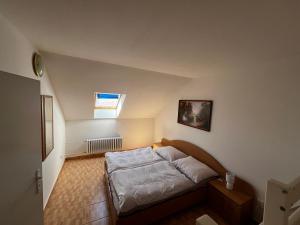 a small bedroom with a bed in a attic at Penzión Dvorec in Dvorec