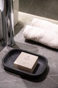 a card on a plate on a counter with towels at Nine Athens Hotel in Athens +92 photos