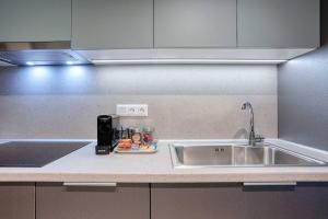 a kitchen counter with a sink next to a sink at Alba Luxury Suite Trikala in Tríkala +32 photos