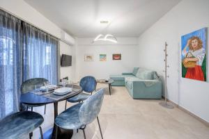 a living room with a table and chairs and a couch at Alba Luxury Suite Trikala in Tríkala