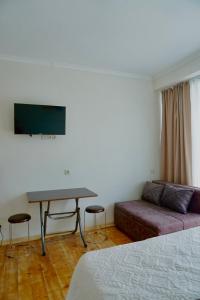 a living room with a couch and a table and a tv at Ferre Hotel Shekvetili in Natanebis Sadguri