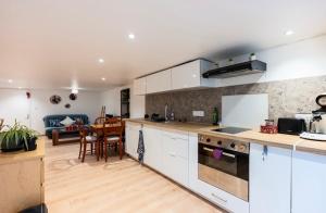 a kitchen with white cabinets and a living room at Le carolo in Tournes