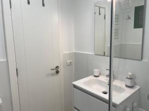 a white bathroom with a sink and a mirror at Beach Flor Bungaló 42 La Gema del Sur in Maspalomas