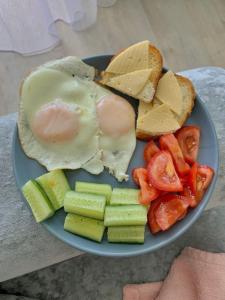 a plate of food with an egg sandwich and vegetables at Central Guest House Karakol in Karakol