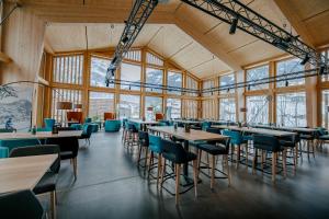 a dining room with tables and chairs and windows at Eiger Lodge Chic in Grindelwald