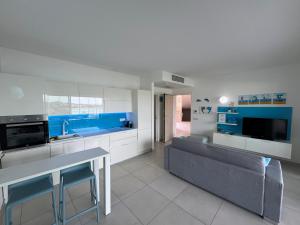 a kitchen with a couch and a table in a room at Appartamento Delfino Bianco in Golfo Aranci +33 photos