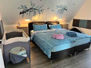 a bedroom with a bed with a blue comforter at Ferienwohnung bei Rheine Neubau 2026 mit Klima Terrasse ruhige Lage in Neuenkirchen