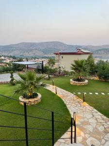 a garden with palm trees and a house at Villa Panorama in Astakos