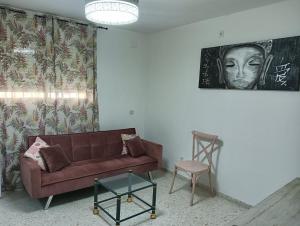 a living room with a couch and a painting on the wall at Ágora House Alcalá de Guadaira 2 in Alcalá de Guadaira