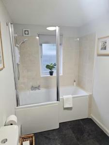 a bathroom with a shower and a tub and a sink at Last Yan - Stylish Ambleside Stay in Ambleside +16 photos