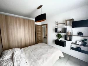 a bedroom with a white bed and shelves at Czarno biały in Racibórz