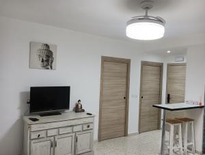 a living room with a flat screen tv on a dresser at Ágora House Alcalá de Guadaira 2 in Alcalá de Guadaira