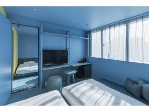 a bedroom with a bed and a desk and a tv at toggle hotel suidobashi - Vacation STAY 06299v in Tokyo