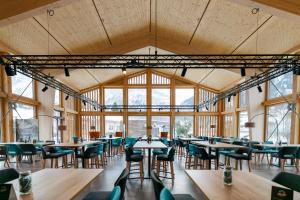 ein Esszimmer mit Tischen, Stühlen und Fenstern in der Unterkunft Eiger Lodge Easy in Grindelwald