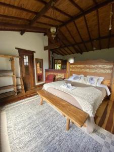 a large bedroom with two beds and a table at Chalés Vista das Montanhas in Lavras Novas
