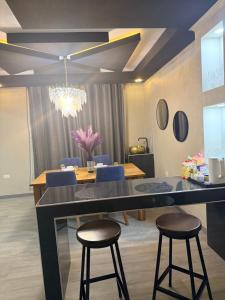 a dining room with a table and two bar stools at Sazeesha Apartments in Ndola +26 photos