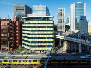 a train in a city with buildings and a bridge at toggle hotel suidobashi - Vacation STAY 06318v in Tokyo +14 photos