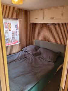 a bed in a room with a striped wall at Mobilhome Apartments in Bechhofen