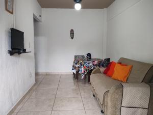 a living room with a couch and a tv at Casa em Saquarema praia e verde in Saquarema