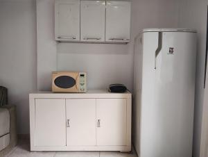 a microwave sitting on a counter next to a refrigerator at Casa em Saquarema praia e verde in Saquarema