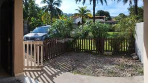 a fence with a car parked in front of a house at Casa em Saquarema praia e verde in Saquarema
