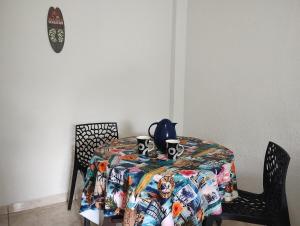 a table with a patterned table cloth and two mugs on it at Casa em Saquarema praia e verde in Saquarema