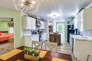 a kitchen with white cabinets and a table and chairs at Explore Tupelo & Natchez Trace! Southern Getaway in Tupelo