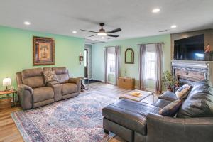 a living room with two leather couches and a fireplace at Explore Tupelo & Natchez Trace! Southern Getaway in Tupelo