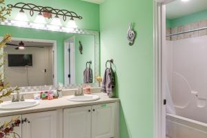 a bathroom with two sinks and a large mirror at Explore Tupelo & Natchez Trace! Southern Getaway in Tupelo +17 photos