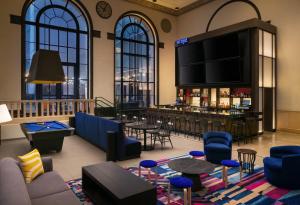 a lobby with a bar with blue chairs and tables at Aloft by Marriott Philadelphia Downtown in Philadelphia