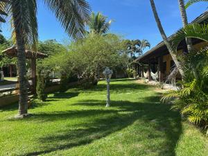 a yard of a house with palm trees and a parking meter at Casa em Praia Seca - Ideal para familia- Piscina- Churrasco- Em Condominio in Araruama